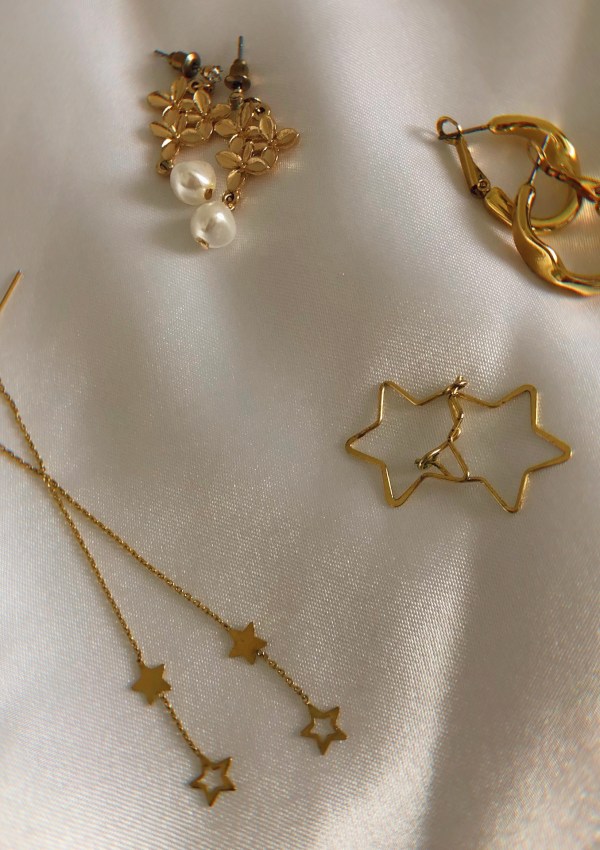 gold earrings on white silk