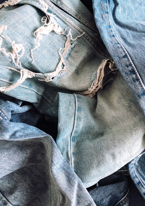 a pile of blue distressed jeans